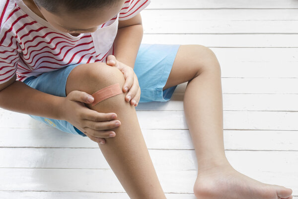 Children wound or The boy had an accident sitting on wooden white background.Top view and zoom in