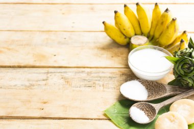 Olgun muz tatlısı ahşap arka planda Hindistan cevizi sütü ve şeker ve tuz gibi doğanın hammadde var. Üst görünüm ve yakın çekim