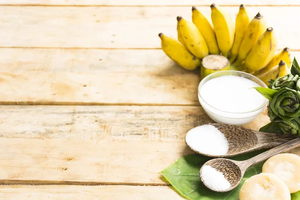 Olgun muz tatlısı ahşap arka planda Hindistan cevizi sütü ve şeker ve tuz gibi doğanın hammadde var. Üst görünüm ve yakın çekim