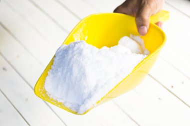 Dekstroz içinde el ahşap beyaz masa üzerinde sarı kürek