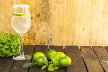 İçinde ahşap arka plan üzerinde cam ve yeşil limon limonata. Sağlık için iç. Yakın çekim.