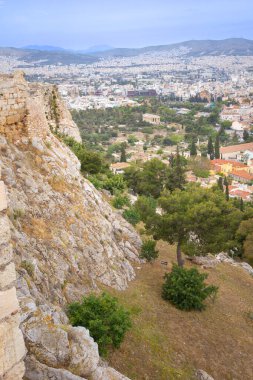 Dikey geniş açı yüksek açı aşağıdaki yoğun şehre dik ve kayalık bir yamaçtan bakarak antik kalıntılar ve modern yumuşak odak binaları arasındaki zıtlığı gösterir.
