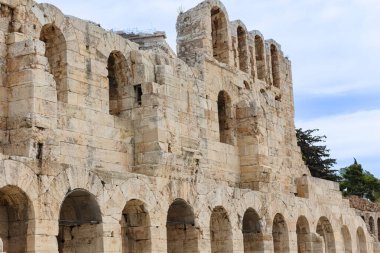 Kaba antik taş mimarisine dikey olarak yakın çekim, iki büyük kemerli açıklık, parlak gökyüzüne karşı çerçevelenmiş, negatif alanı vurguluyor