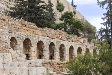 Kaba antik taş mimarisine dikey olarak yakın çekim, iki büyük kemerli açıklık, parlak gökyüzüne karşı çerçevelenmiş, negatif alanı vurguluyor
