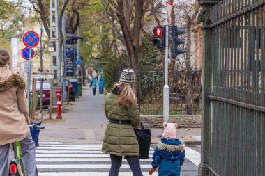 Budapeşte, Macaristan - 24 Ekim 2025: Anne ve çocuk yaya geçidinden karşıya geçiyor