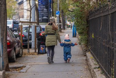 Budapeşte, Macaristan - 24 Ekim 2025: Anne ve çocuk yaya geçidinden karşıya geçiyor