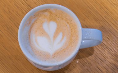 Çilekli kek diliminin yatay geniş açılı üst görüntüsü ve bir kafedeki ahşap masada bir fincan kahve, yemek blogları için mükemmel.