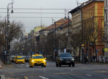 Budapeşte, Macaristan - 24 Ekim 2025: Oktogon yakınlarındaki Grand Boulevard 'da sürmekte olan sarı Bolt taksi
