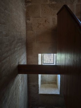 Taş bir duvarda parmaklıkları olan pencere