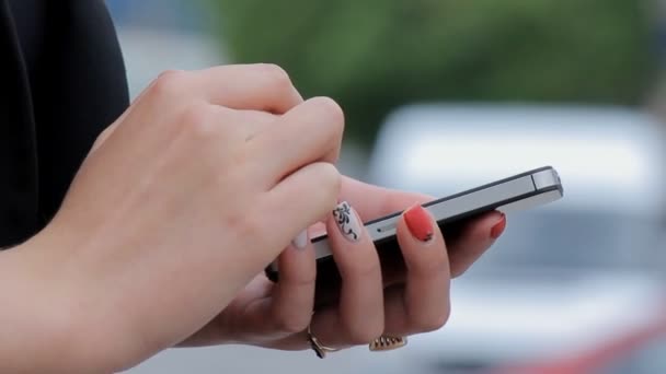 Vrouw werkt op smartphone - stedelijke straat met auto's - stad - closeup — Stockvideo