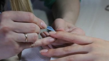 Teknisyen Müşteri bir manikür, tırnak salonu veren tırnak. Genç kadın bir Fransız manikür alma.