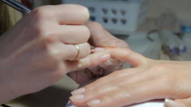 Teknisyen Müşteri bir manikür, tırnak salonu veren tırnak. Genç kadın bir Fransız manikür alma.
