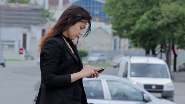 Mujer con smartphone caminando por la ciudad al atardecer. Steadicam tiro — Vídeos de Stock