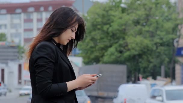 Frau mit Smartphone bei Sonnenuntergang in der Stadt unterwegs. Steadicam-Aufnahme — Stockvideo