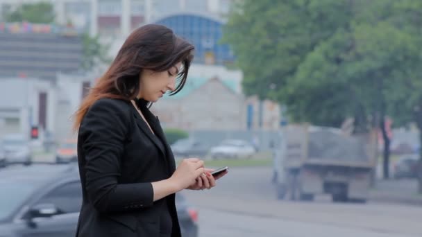 Donna con smartphone che cammina in città al tramonto. Steadicam shot — Video Stock