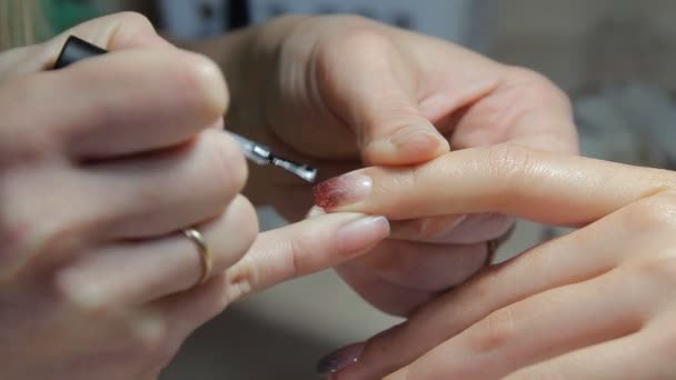 Nageltechniker gibt Kunden eine Maniküre im Nagelstudio. junge Frau erhält eine französische Maniküre. — Stockvideo
