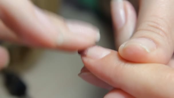 Nail technician giving customer a manicure at nail salon. Young woman receiving a french manicure. — Stock Video