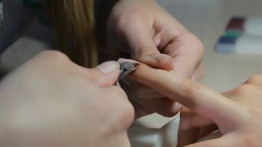 Teknisyen Müşteri bir manikür, tırnak salonu veren tırnak. Genç kadın bir Fransız manikür alma.