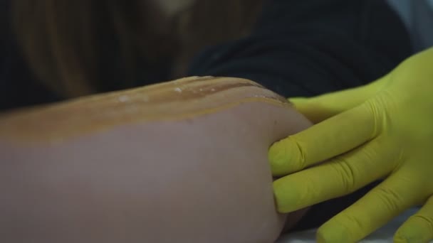 Beautician depilación femenina pierna en spa de belleza. Procedimiento para las piernas shugaring. — Vídeo de stock