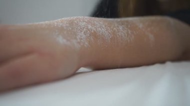 Güzellik uzmanı vücudunda lazer tüy aldırmak için bir yer hazırlıyor..