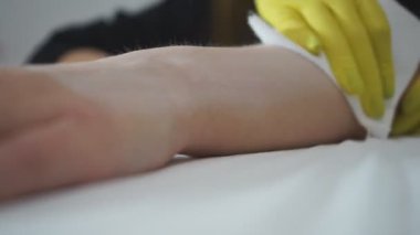 Güzellik uzmanı vücudunda lazer tüy aldırmak için bir yer hazırlıyor..