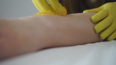 Güzellik uzmanı vücudunda lazer tüy aldırmak için bir yer hazırlıyor..