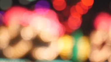 Parlayan ışıkların arka planı. Çok renkli ışık, parlayan Noel çelenklerinin bulanık arkaplanının 4k görüntüsüne sızar