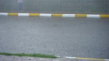 Dışarıda şiddetli yağmur var. Sağanak yağış sırasında büyük yağmur damlaları yola düşer. Su damlaları. Duş al