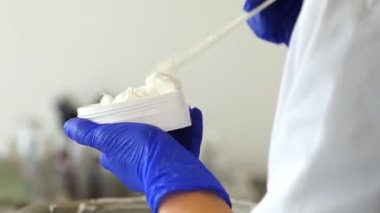 Elle doldurulmuş tıbbi krem. Bir ilaç fabrikası, bir işçi bir kavanoz krema dolduruyor. Tıbbi ürünler. Sağlık sektörü.