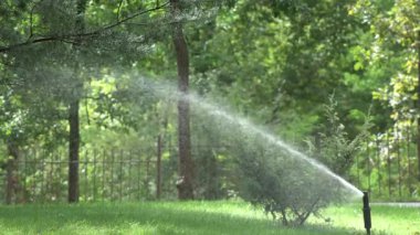 Çeşmeden yakın plan su sıçrıyor. Paslanmaz çelik su çeşmesi. Halk parkında fıskiye fıskiyeleri. Paslanmaz ızgaradan akan nehirler..