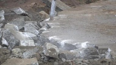 Ağır hidrolik çekiç kazıcısıyla beton kaldırımı eziyor.