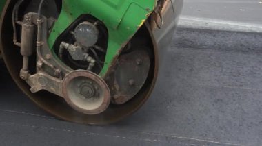 Bir silindir yeni asfalt serer. Özel teçhizat yol açıyor. Bir sıkıştırıcı bir otoyol inşa eder. Bir buharlı silindir yavaş hareket eder. Ağır ekipmanlı yol yapımı.