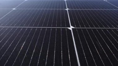 Yeşil bitki örtüsü ve çimlerle çevrili sıra sıra güneş çiftliklerinin insansız hava aracı.