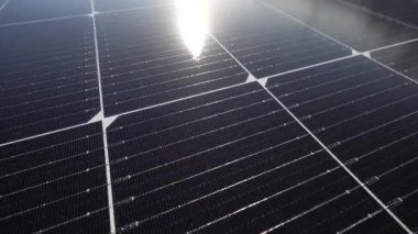 Yeşil bitki örtüsü ve çimlerle çevrili sıra sıra güneş çiftliklerinin insansız hava aracı.