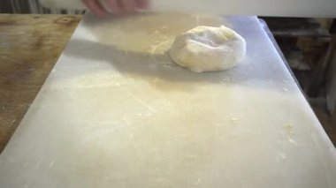 Taze hamuru mutfak tahtasının ince tabakasına elle dök..