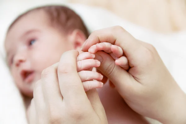 Las palmas pequeñas del bebé recién nacido en las manos de las madres — Foto de Stock