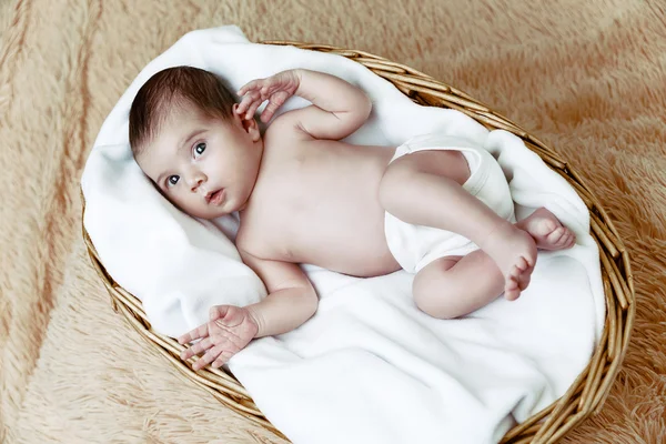 Newborn baby lying in wicker basket — Stock Photo, Image