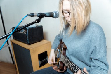 Gitar ve şarkı mikrofon oynayan genç kadın