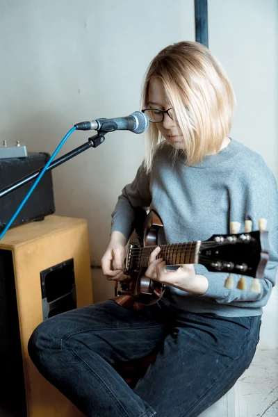 Jeune femme jouant de la guitare et chantant microphone — Photo