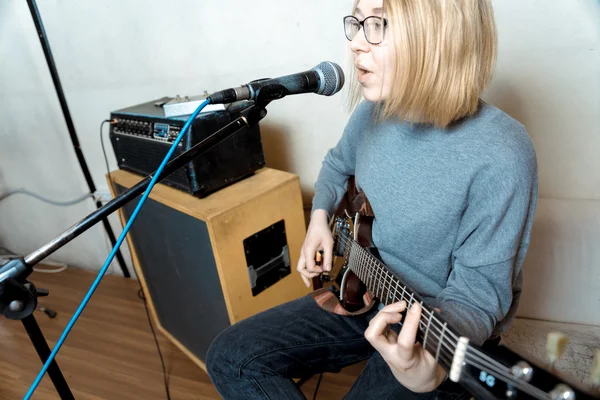Jonge vrouw spelen gitaar en zang microfoon — Stockfoto