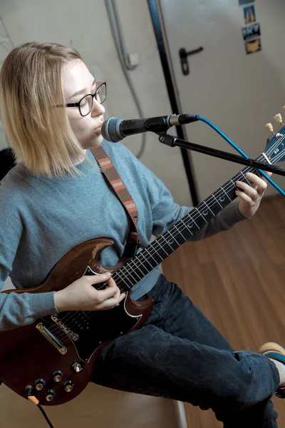 Jonge vrouw spelen gitaar en zang microfoon — Stockfoto