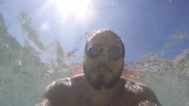 Genç adam bir şey sualtı görünüyor