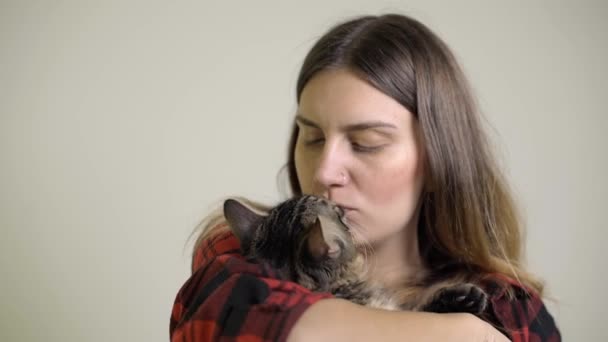 Mujer cuida - le gusta - besos un gatito en su vuelta — Vídeo de stock