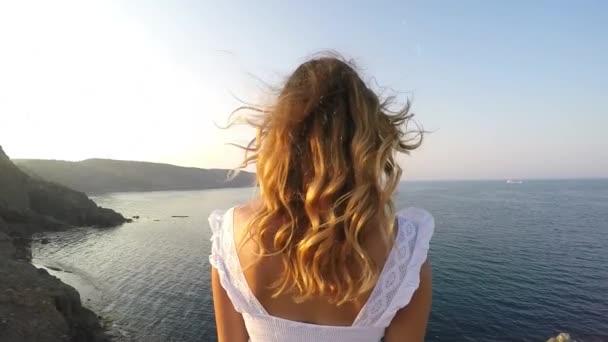 Žena se dívá na moře - je na kopci a je slunce - Zpomalený pohyb — Stock video
