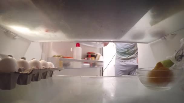 Een man die het rapen van de eieren uit koelkast — Stockvideo