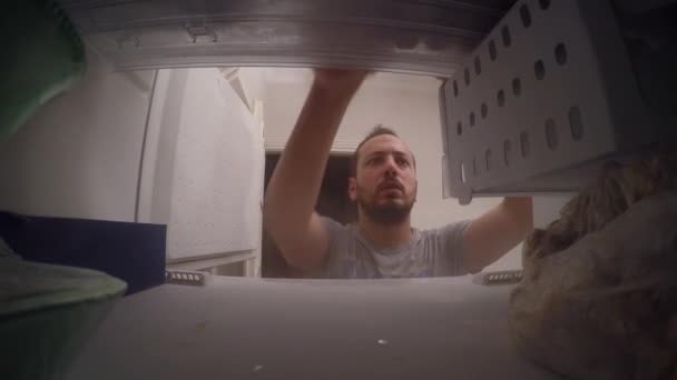 Mann holt Eis aus der Tiefkühltruhe — Stockvideo