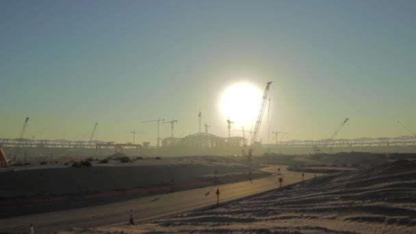 Die aufgehende Sonne erscheint hinter einem Silhouettengebäude der Baustelle - Zeitraffer - Weitwinkel — Stockvideo