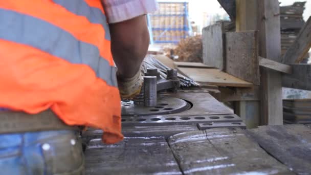 Trabajador está torciendo los materiales de construcción de tubos de acero en un sitio de construcción — Vídeo de stock