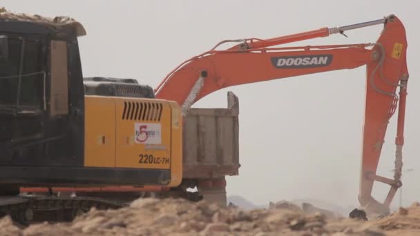 Madina - Arabia Saudita 8 diciembre 2014 - Excavator scoop loads a dump truck — Vídeo de stock