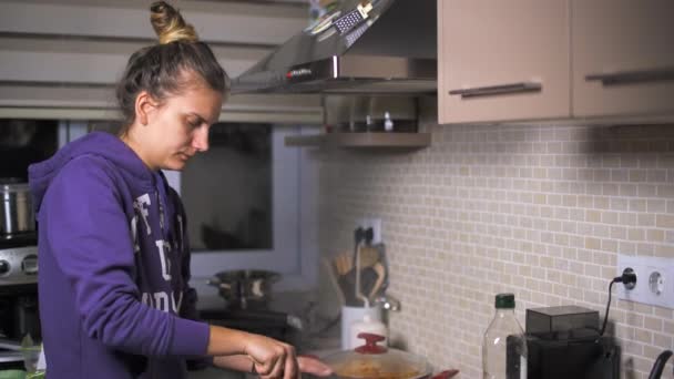 Kvinnan är matlagning i köket — Stockvideo